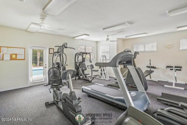 gym with a healthy amount of sunlight, a textured ceiling, and ceiling fan