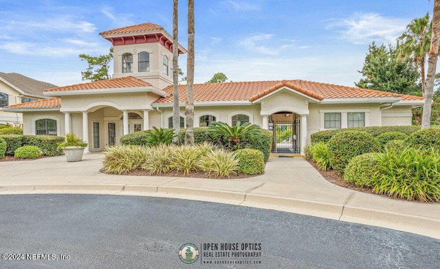 view of front of home with a gate, a tile roof, and stucco siding