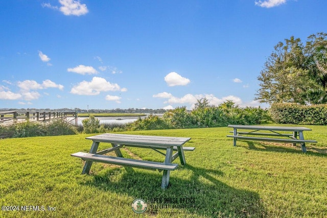 view of home's community featuring a water view and a lawn