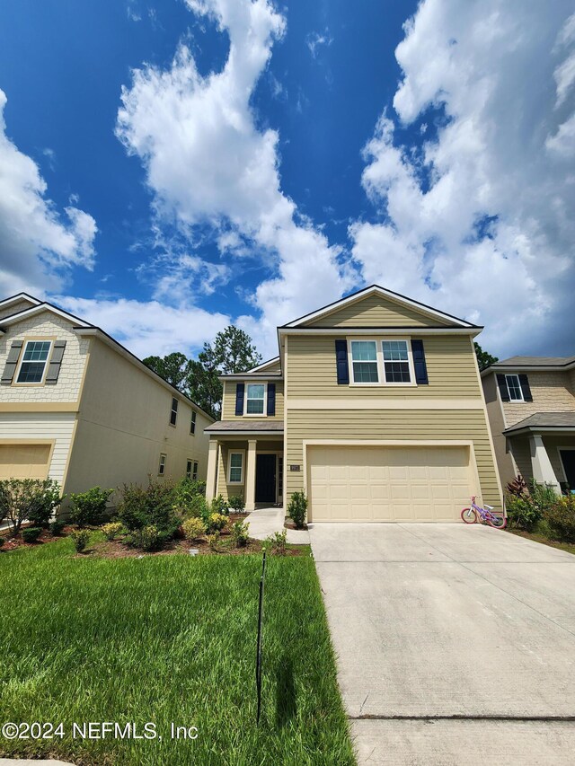 view of front of home featuring a front lawn and a garage