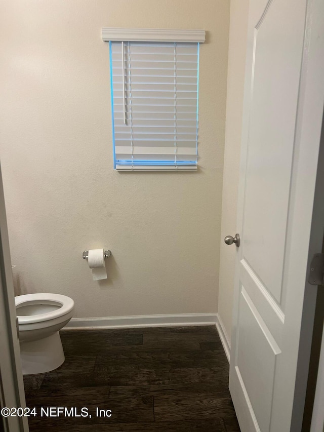 bathroom with wood finished floors, toilet, and baseboards