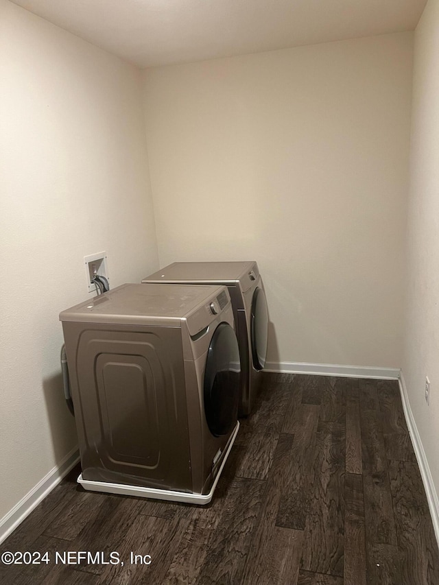 washroom featuring laundry area, dark wood finished floors, washer and clothes dryer, and baseboards