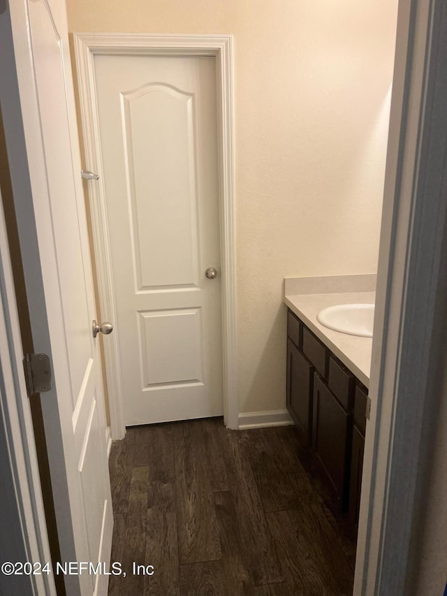 bathroom with baseboards, wood finished floors, and vanity