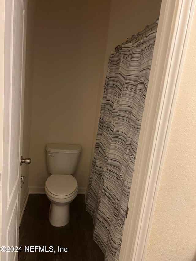 full bath featuring toilet, baseboards, and wood finished floors