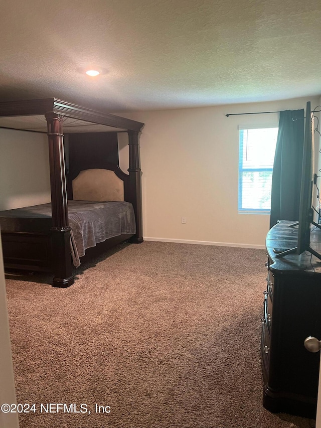 carpeted bedroom with a textured ceiling and baseboards