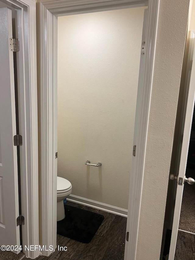 bathroom featuring baseboards, toilet, and wood finished floors