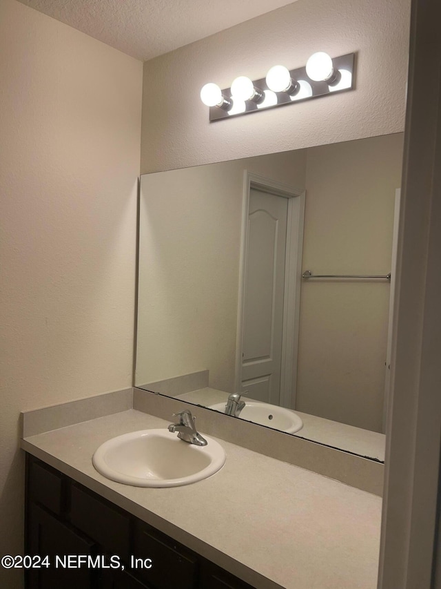 bathroom featuring a textured ceiling and vanity