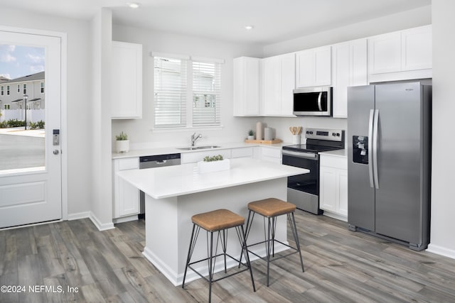 kitchen featuring sink, stainless steel appliances, white cabinets, and a kitchen island