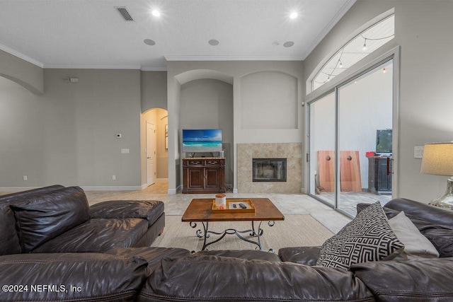 living room with ornamental molding and a tile fireplace