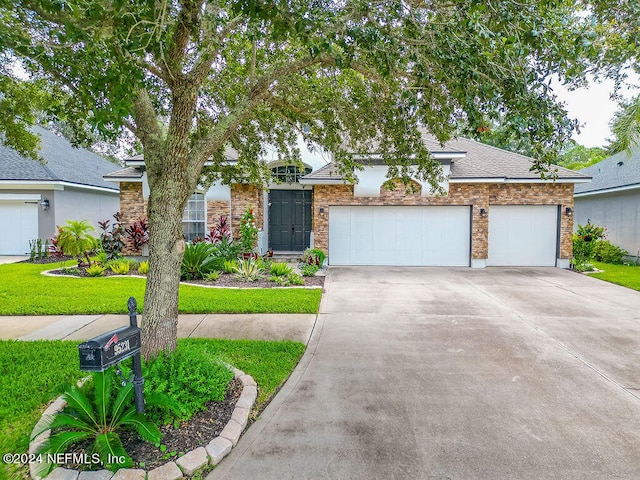 view of front of home with a front yard and a garage