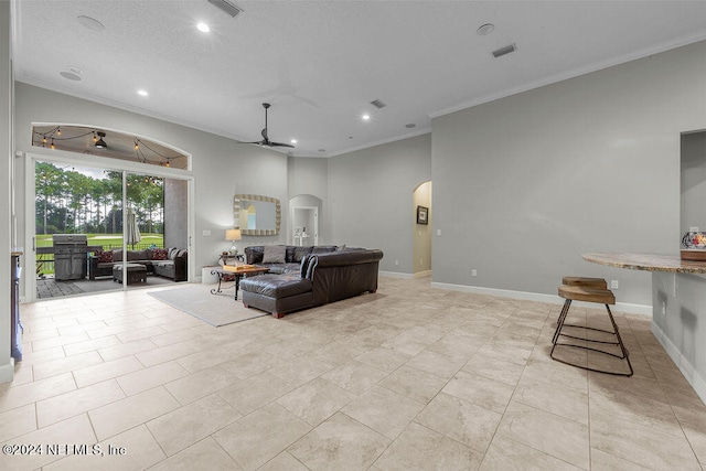 living room featuring ornamental molding, light tile patterned flooring, and ceiling fan