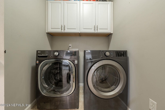 laundry area with washing machine and clothes dryer and cabinets