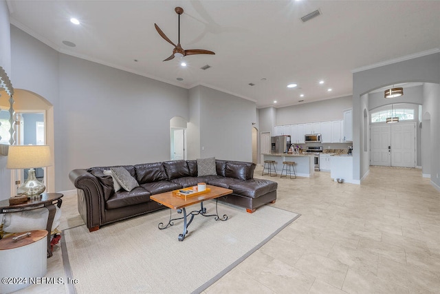 tiled living room with crown molding, a wealth of natural light, and ceiling fan