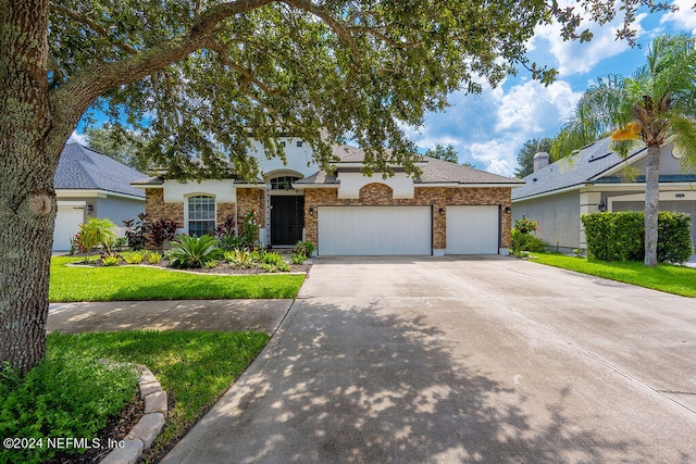 ranch-style house featuring a front yard and a garage