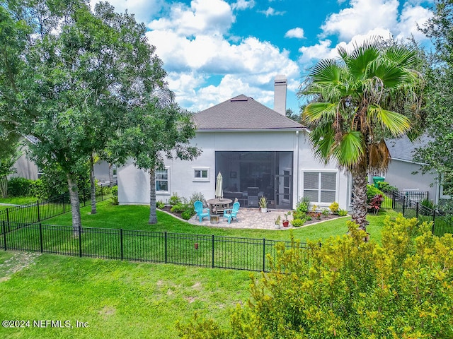 back of house with a patio, a fire pit, a sunroom, and a lawn