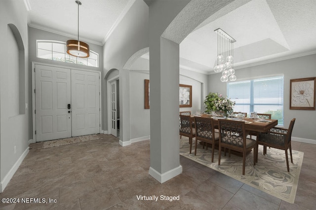 foyer with ornamental molding, a textured ceiling, and an inviting chandelier