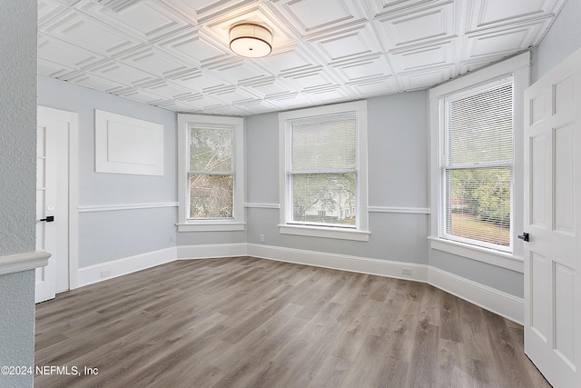 spare room with light wood-style floors, an ornate ceiling, and baseboards