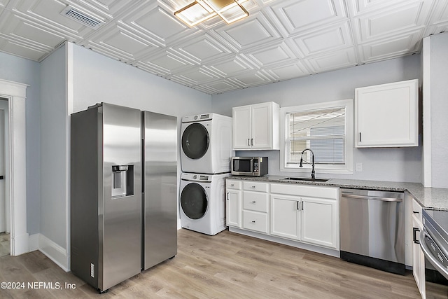 kitchen featuring an ornate ceiling, visible vents, appliances with stainless steel finishes, a sink, and stacked washing maching and dryer