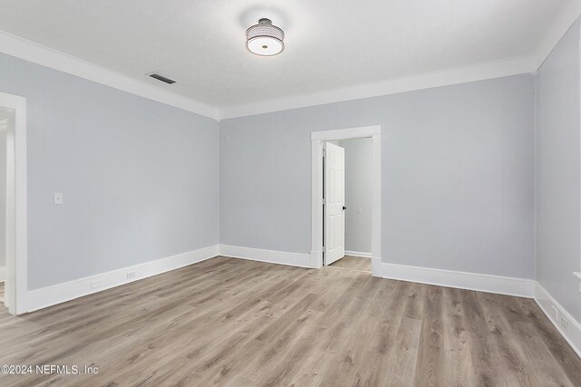 unfurnished room featuring light wood-type flooring and ornamental molding