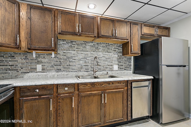 kitchen with a sink, freestanding refrigerator, electric range oven, tasteful backsplash, and crown molding