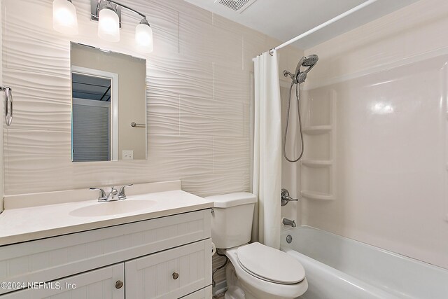 full bathroom featuring tile walls, shower / bathtub combination with curtain, toilet, and vanity