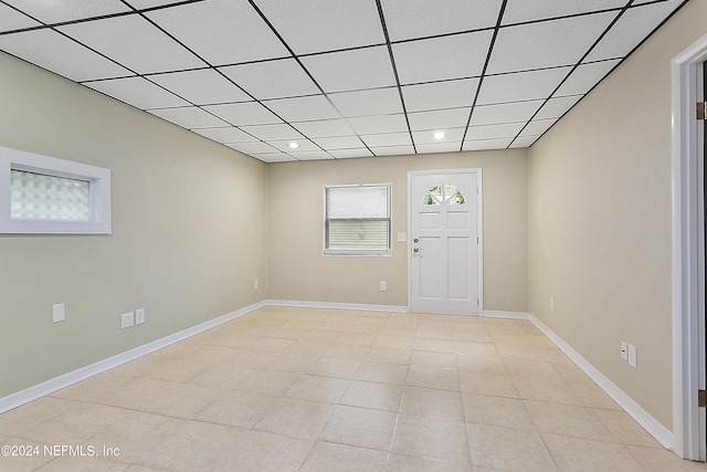 empty room featuring a paneled ceiling, light tile patterned floors, baseboards, and recessed lighting