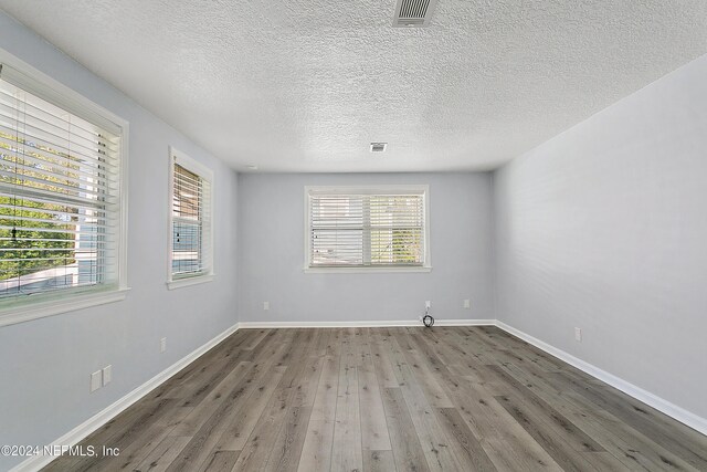 unfurnished room with hardwood / wood-style floors and a wealth of natural light