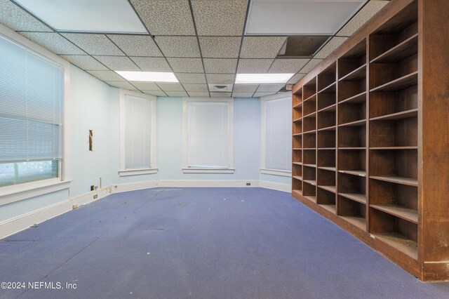 carpeted spare room with a drop ceiling