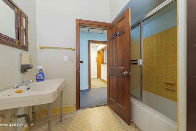 full bathroom featuring shower / bath combination with glass door and baseboards