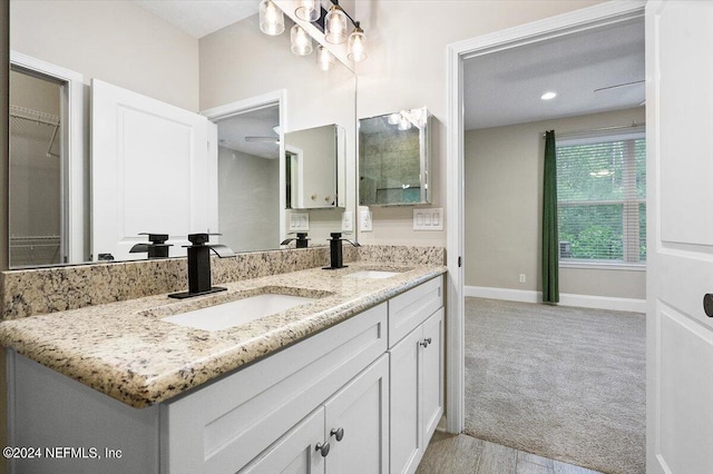 bathroom with a sink, baseboards, and double vanity