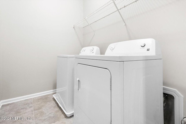 clothes washing area featuring laundry area, washing machine and dryer, and baseboards