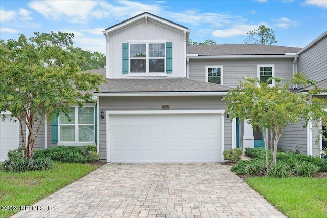 view of front of house with a garage, decorative driveway, and board and batten siding