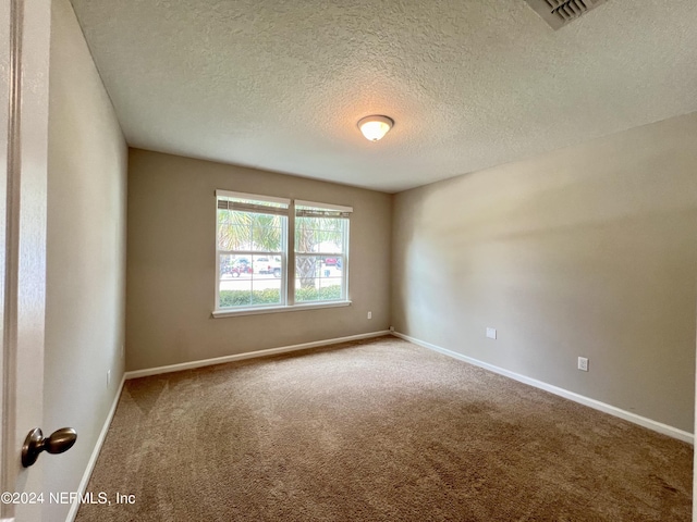 carpeted spare room featuring a textured ceiling