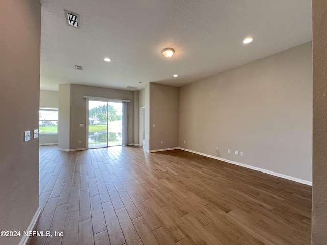 spare room with wood-type flooring and a textured ceiling