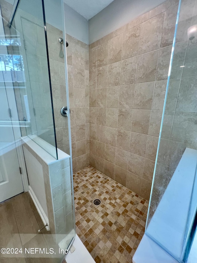 bathroom with hardwood / wood-style flooring and tiled shower