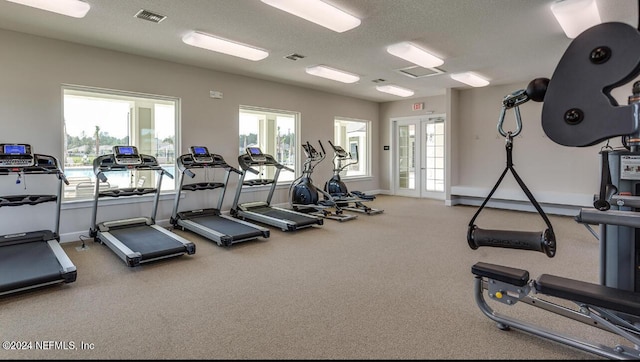 gym featuring french doors and a textured ceiling