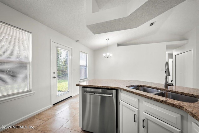 kitchen featuring white cabinets, vaulted ceiling, sink, light tile patterned floors, and dishwasher