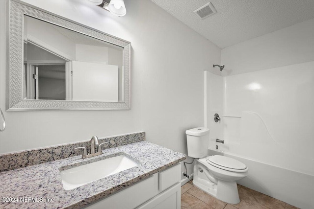 full bathroom with shower / tub combination, vanity, tile patterned flooring, and toilet