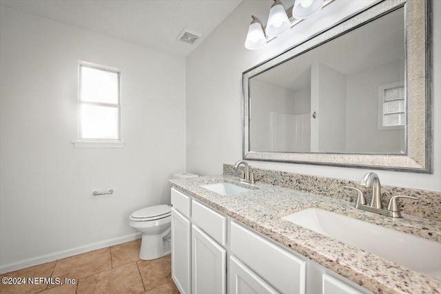 bathroom with tile patterned flooring, toilet, and dual bowl vanity