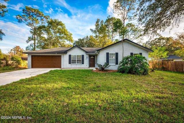 single story home with a garage and a front lawn