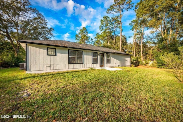 back of house with a lawn and cooling unit