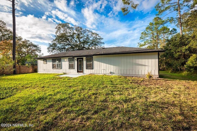 rear view of property with a lawn