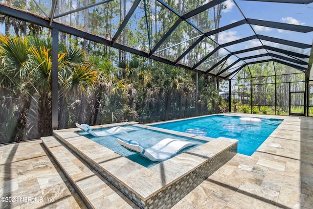 view of swimming pool with an in ground hot tub, glass enclosure, and a patio