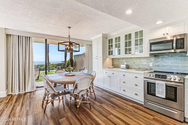 dining space featuring dark wood-style floors, recessed lighting, a textured ceiling, and an inviting chandelier