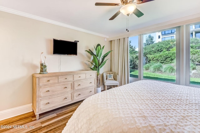 bedroom with ornamental molding, wood finished floors, a ceiling fan, and baseboards