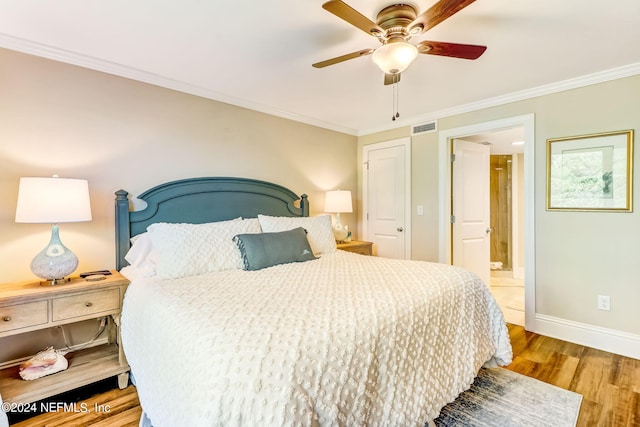 bedroom with visible vents, crown molding, baseboards, and wood finished floors