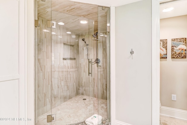 full bath featuring a shower stall and baseboards