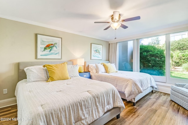 bedroom with multiple windows, ornamental molding, and wood finished floors