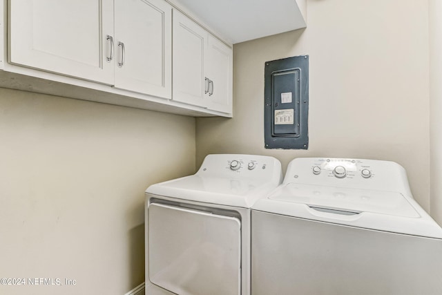 laundry area featuring electric panel, cabinet space, and washer and clothes dryer