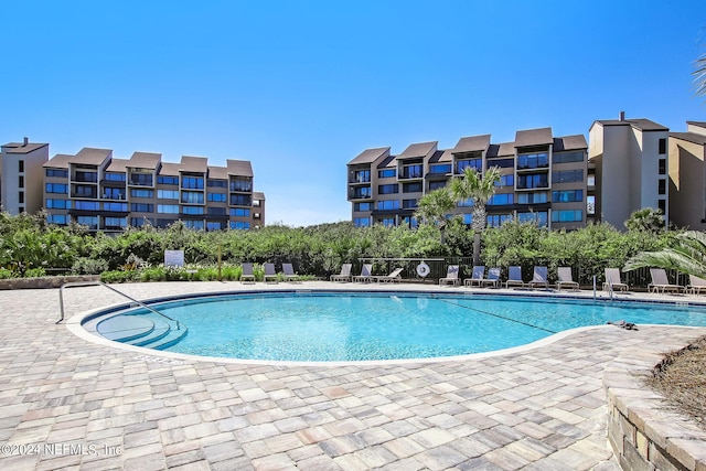 pool with a patio area and fence